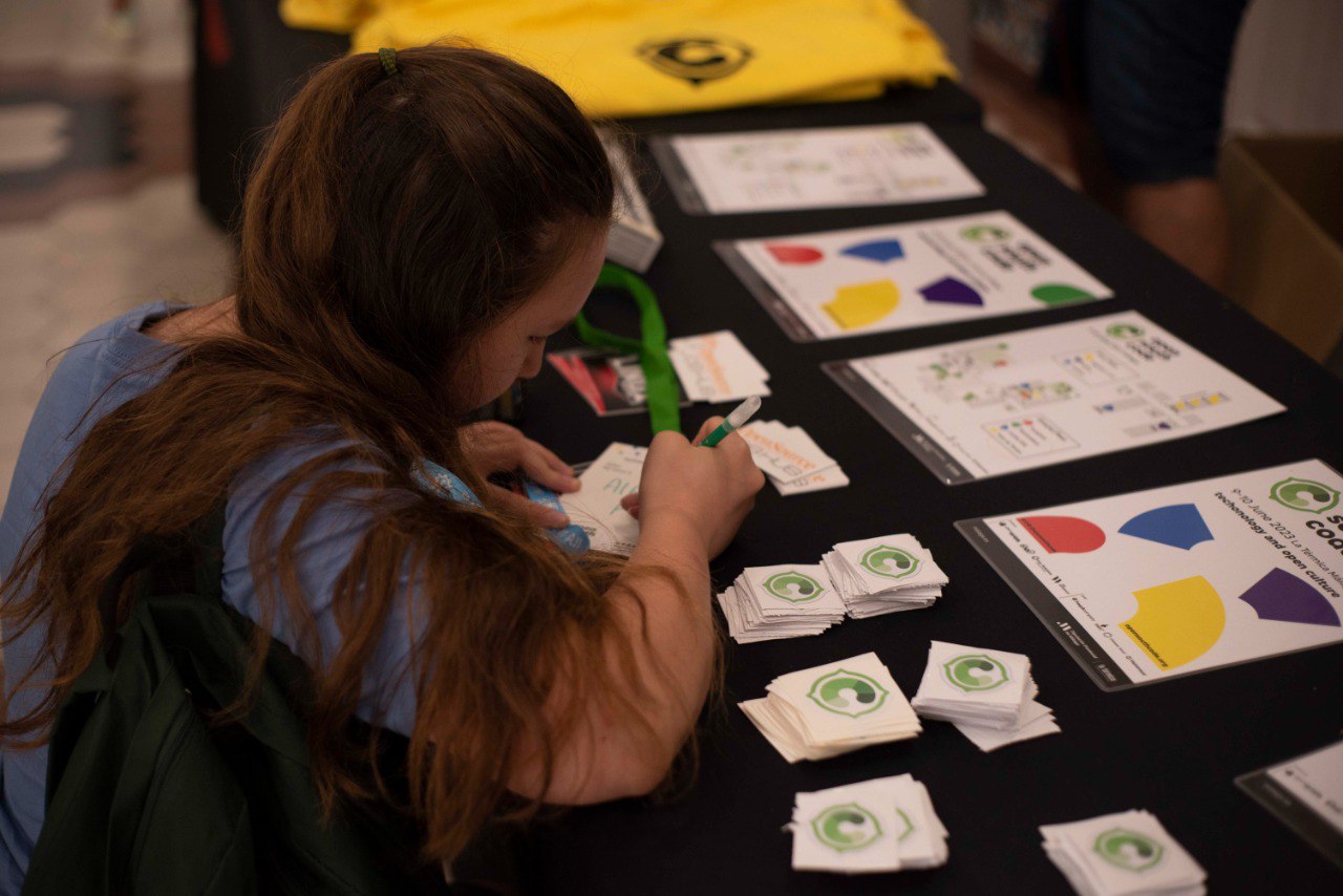 Vista de una niña participando en OpenSouthCode mientras está personalizando su acreditación del evento.
